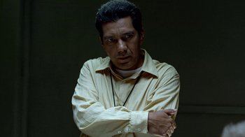 Movie still from “Breaking Bad” (2008), created by Vince Gilligan – A man with his arms crossed wearing a yellow shirt; Close Up shot, Low angle