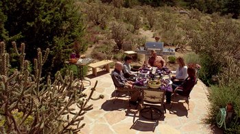 Movie still from “Breaking Bad” (2008), created by Vince Gilligan – A group of people sitting at a table outside; Wide shot, High angle
