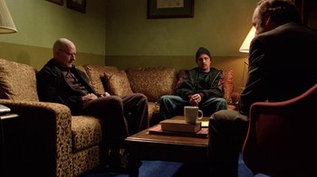 Movie still from “Breaking Bad” (2008), created by Vince Gilligan – A group of people sitting on a couch in a living room; Wide shot, Over the shoulder angle