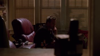 Movie still from “Breaking Bad” (2008), created by Vince Gilligan – A man sitting on a couch in front of a window; Medium shot, High angle