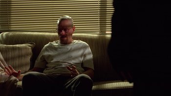 Movie still from “Breaking Bad” (2008), created by Vince Gilligan – An older man sitting on a couch talking to someone; Medium shot, Over the shoulder angle