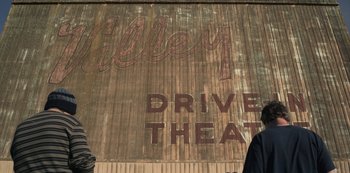 Movie still from “Paddleton” (2019), directed by Alex Lehmann – An old drive - in theater sign painted on the side of a building; Wide shot, Low angle