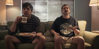 Movie still from “Paddleton” (2019), directed by Alex Lehmann – A couple of men sitting on top of a green couch; Medium shot, Low angle