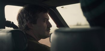 Movie still from “Paddleton” (2019), directed by Alex Lehmann – A man sitting in the back seat of a car looking out the window; Close Up shot, Over the shoulder angle