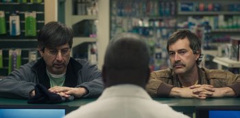 Movie still from “Paddleton” (2019), directed by Alex Lehmann – A group of men sitting at a table in a room; Close Up shot, Over the shoulder angle