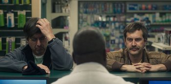 Movie still from “Paddleton” (2019), directed by Alex Lehmann – A group of men sitting at a table in a room; Close Up shot, Over the shoulder angle