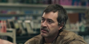 Movie still from “Paddleton” (2019), directed by Alex Lehmann – A person sitting in a chair; Close Up shot, Over the shoulder angle