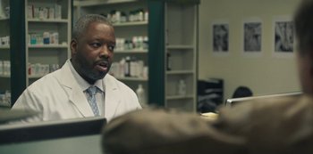 Movie still from “Paddleton” (2019), directed by Alex Lehmann – A man in a lab coat sitting at a desk; Close Up shot, Over the shoulder angle