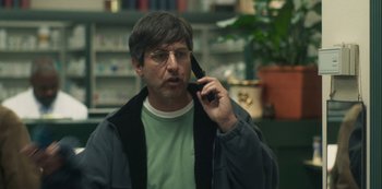 Movie still from “Paddleton” (2019), directed by Alex Lehmann – A man talking on a cell phone while wearing glasses; Close Up shot, Low angle