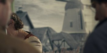 Movie still from “Paddleton” (2019), directed by Alex Lehmann – A person's face with a building in the background; Close Up shot, Low angle