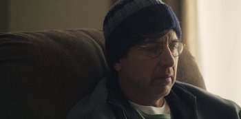 Movie still from “Paddleton” (2019), directed by Alex Lehmann – A person wearing glasses and wearing a hat; Close Up shot, Over the shoulder angle