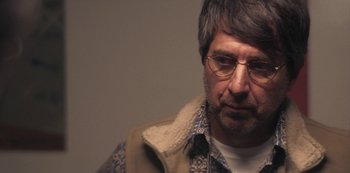 Movie still from “Paddleton” (2019), directed by Alex Lehmann – A person wearing glasses and a jacket; Close Up shot, Over the shoulder angle