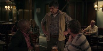 Movie still from “Paddleton” (2019), directed by Alex Lehmann – A group of people sitting around a table; Medium shot, Over the shoulder angle