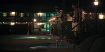 Movie still from “Paddleton” (2019), directed by Alex Lehmann – Two men standing next to a pool at night; Wide shot, Over the shoulder angle