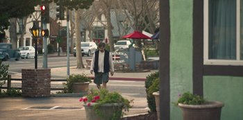 Movie still from “Paddleton” (2019), directed by Alex Lehmann – A man walking down the sidewalk of a city street; Wide shot, High angle