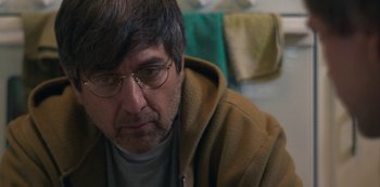 Movie still from “Paddleton” (2019), directed by Alex Lehmann – A person wearing glasses and a hooded jacket; Close Up shot, Over the shoulder angle