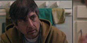 Movie still from “Paddleton” (2019), directed by Alex Lehmann – A person wearing glasses and a hooded jacket; Close Up shot, Over the shoulder angle