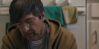 Movie still from “Paddleton” (2019), directed by Alex Lehmann – A person wearing glasses and a hooded jacket; Close Up shot, Over the shoulder angle