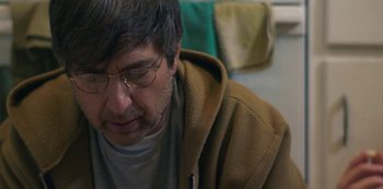 Movie still from “Paddleton” (2019), directed by Alex Lehmann – A person wearing glasses and looking down; Close Up shot, Over the shoulder angle