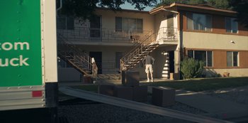 Movie still from “Paddleton” (2019), directed by Alex Lehmann – A man standing in front of an apartment building; Extreme Wide shot, High angle