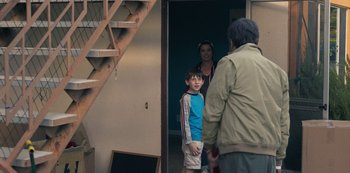 Movie still from “Paddleton” (2019), directed by Alex Lehmann – A woman and a man standing next to a young boy; Medium shot, Over the shoulder angle