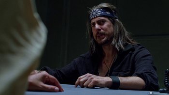Movie still from “Breaking Bad” (2008), created by Vince Gilligan – A man sitting at a table wearing a headband; Close Up shot, Over the shoulder angle