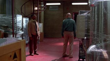 Movie still from “Breaking Bad” (2008), created by Vince Gilligan – Two men standing in an industrial setting looking at each other; Wide shot, Low angle