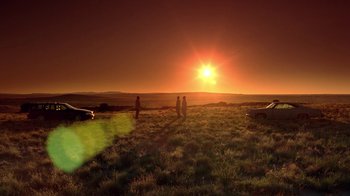Movie still from “Breaking Bad” (2008), created by Vince Gilligan – A group of people standing on top of a grass covered field; Extreme Wide shot, Low angle