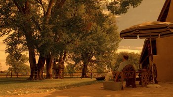 Movie still from “Breaking Bad” (2008), created by Vince Gilligan – A person sitting on a bench near a tree; Extreme Wide shot, Low angle