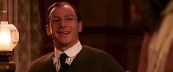 Movie still from “Peter Pan” (2003), directed by P.J. Hogan – A man in a suit and tie smiling for the camera; Close Up shot, Low angle