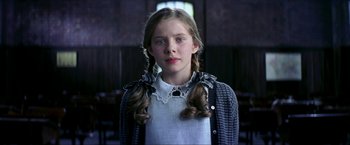 Movie still from “Peter Pan” (2003), directed by P.J. Hogan – A young girl with long braids wearing a white shirt and a sweater; Close Up shot, Low angle