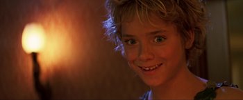 Movie still from “Peter Pan” (2003), directed by P.J. Hogan – A young boy smiling for the camera; Close Up shot, Low angle