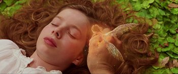 Movie still from “Peter Pan” (2003), directed by P.J. Hogan – A woman laying on top of a grass covered field; Close Up shot, Overhead angle