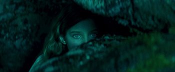 Movie still from “Peter Pan” (2003), directed by P.J. Hogan – A woman with blue eyes peeking out from behind a tree trunk; Close Up shot, Overhead angle