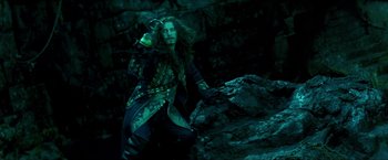 Movie still from “Peter Pan” (2003), directed by P.J. Hogan – A man dressed as a pirate standing next to a rock; Medium shot, High angle