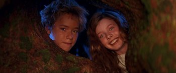 Movie still from “Peter Pan” (2003), directed by P.J. Hogan – Two young children are smiling for the camera; Close Up shot, Low angle
