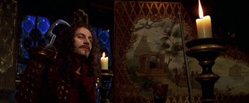 Movie still from “Peter Pan” (2003), directed by P.J. Hogan – A man with long curly hair standing in front of a painting; Medium shot, Low angle