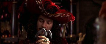 Movie still from “Peter Pan” (2003), directed by P.J. Hogan – A man wearing a red hat and holding a pair of scissors; Close Up shot, High angle