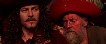 Movie still from “Peter Pan” (2003), directed by P.J. Hogan – A man with long hair and a beard and a man with long hair and a beard; Close Up shot, Over the shoulder angle