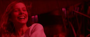 A woman in a white shirt is smoking a cigarette