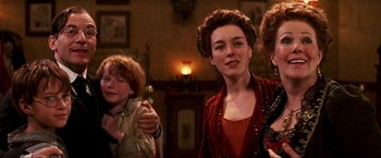 Movie still from “Peter Pan” (2003), directed by P.J. Hogan – A group of people standing in front of a fireplace; Close Up shot, Over the shoulder angle
