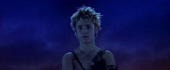 Movie still from “Peter Pan” (2003), directed by P.J. Hogan – A young man with blonde curly hair wearing a black dress; Close Up shot, Low angle