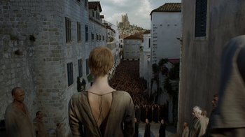 Movie still from “Game of Thrones” (2011), created by D.B. Weiss – A woman standing in front of a group of people; Wide shot, High angle
