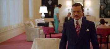 Movie still from “Ratched” (2020), created by Evan Romansky – A man in a suit standing in front of two other people; Medium shot, Over the shoulder angle