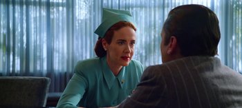 Movie still from “Ratched” (2020), created by Evan Romansky – A woman wearing a hat and a green suit; Close Up shot, Over the shoulder angle