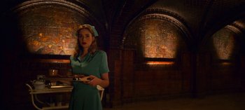 Movie still from “Ratched” (2020), created by Evan Romansky – A woman holding a tray in a dimly - lit room; Medium shot, Low angle