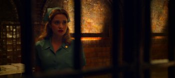 Movie still from “Ratched” (2020), created by Evan Romansky – A woman in a green shirt looking out of a window; Medium shot, Low angle