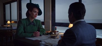 Movie still from “Ratched” (2020), created by Evan Romansky – A woman in a green dress and a man in a green suit are sitting at a table; Medium shot, Over the shoulder angle