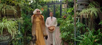 Movie still from “Ratched” (2020), created by Evan Romansky – An older woman and a younger man walking down a path; Wide shot, Low angle