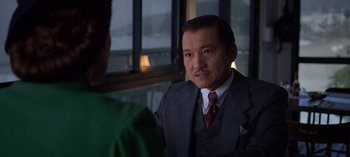 Movie still from “Ratched” (2020), created by Evan Romansky – A man wearing a suit and tie in front of a window; Close Up shot, Over the shoulder angle
